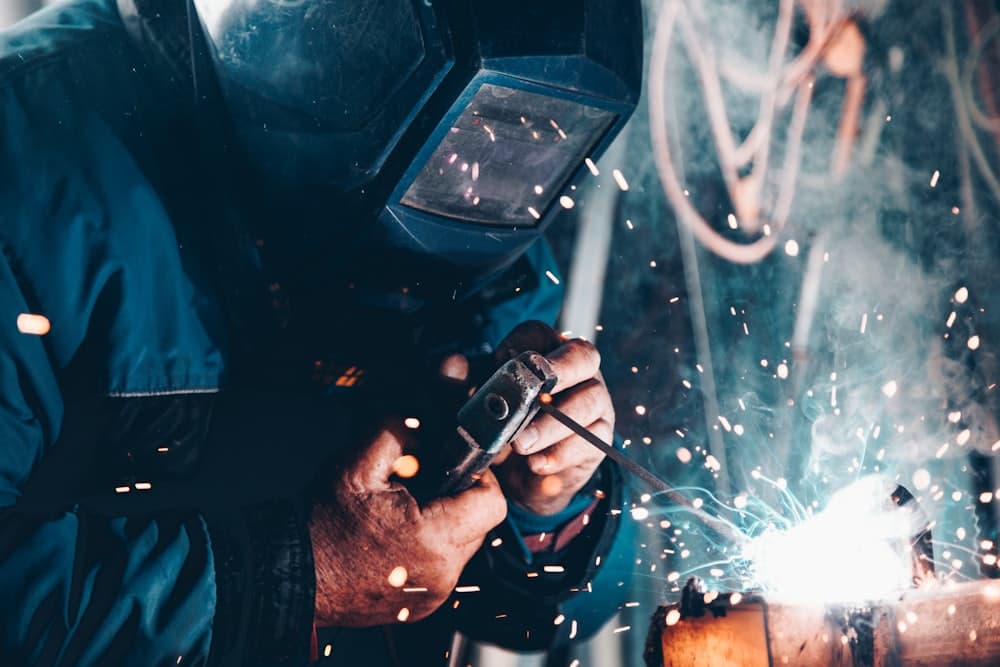 On-site technician performing maintenance with sparks flying — SIMPL Industrial & Mining Power field service